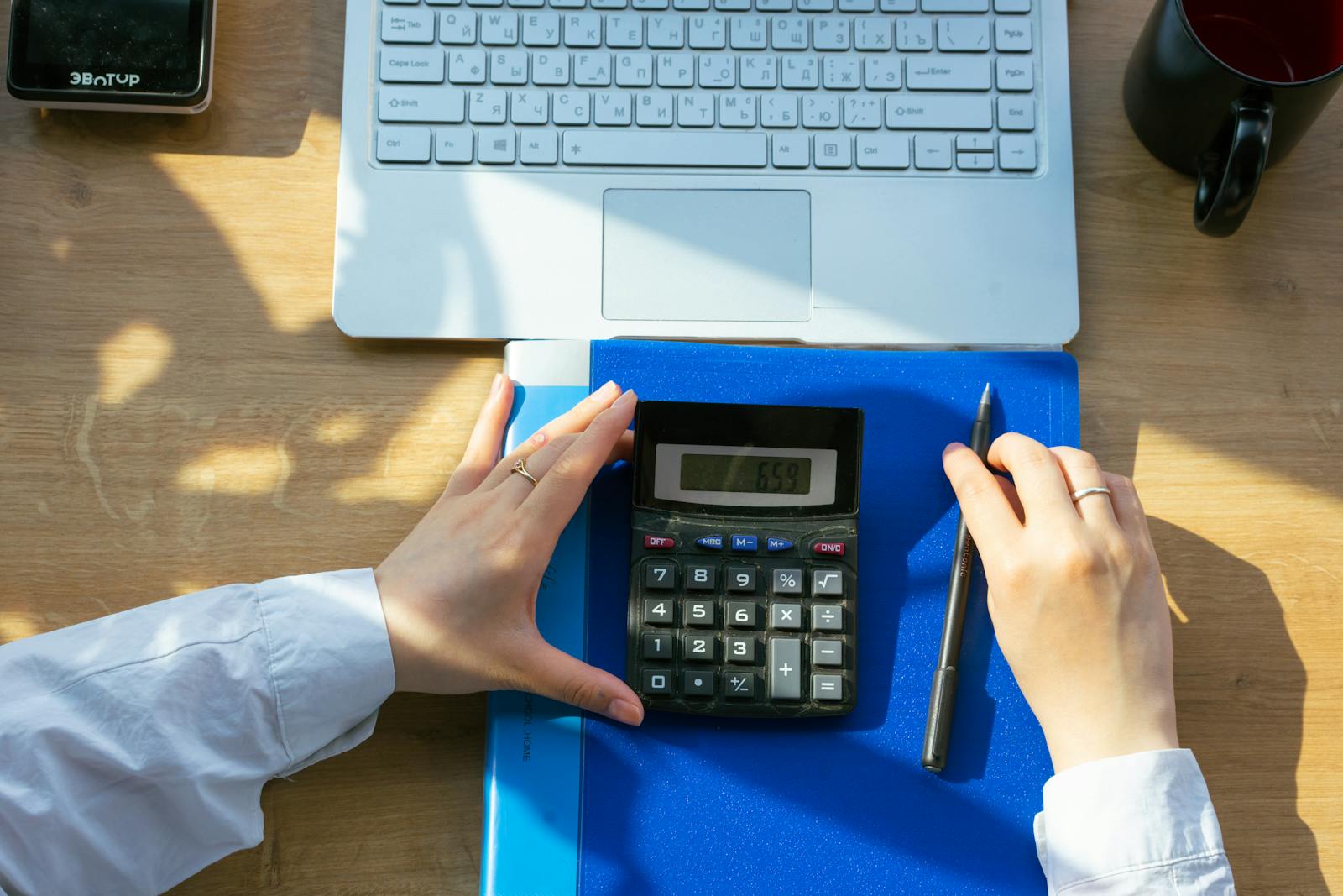 Temporary comp image of a calculator, laptop, and planning documents on a desk.